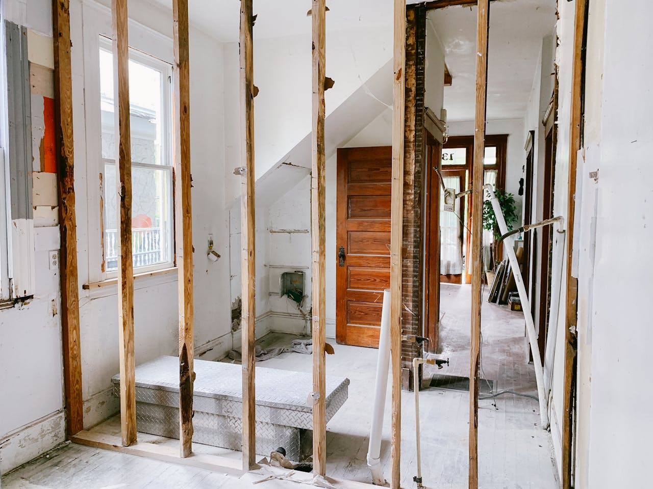 ours-journey Interior view of a home under renovation with exposed wooden beams and door.