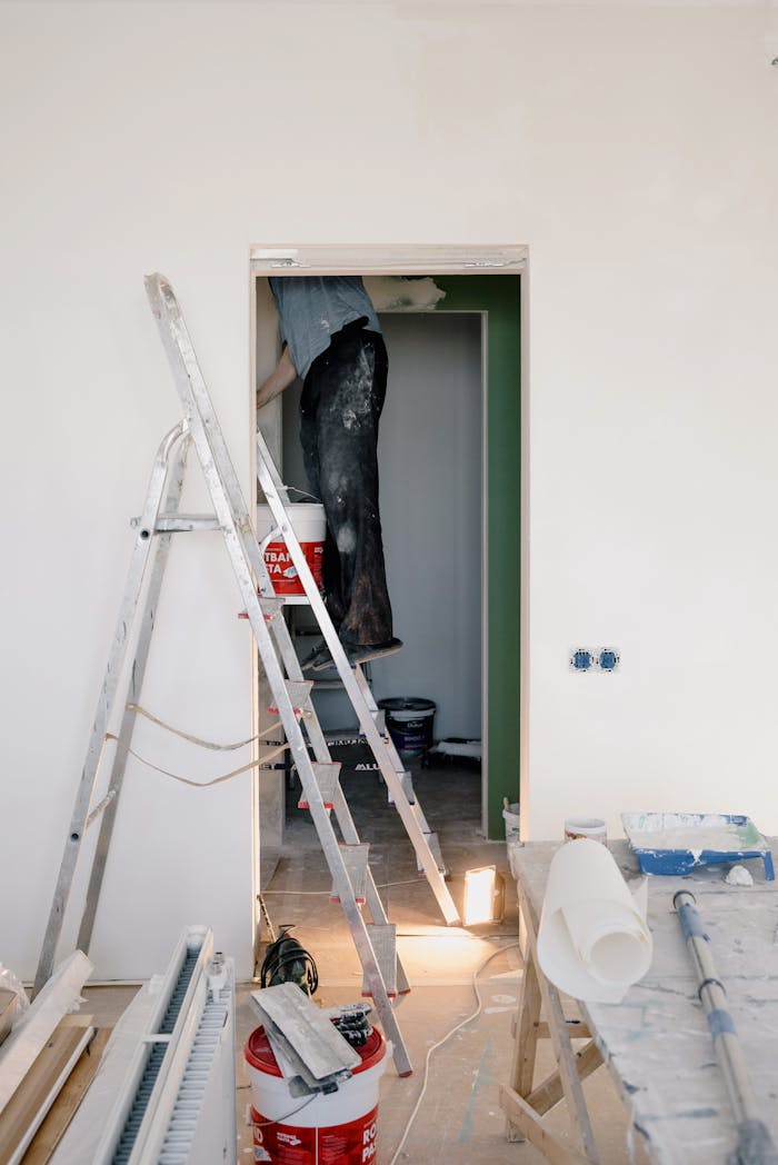 contact-img Crop unrecognizable male in dirty clothes working in room during renovation works at home